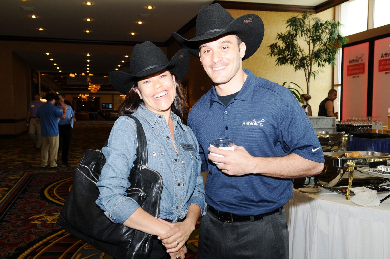 A man and woman wearing cowboy hats at an event.