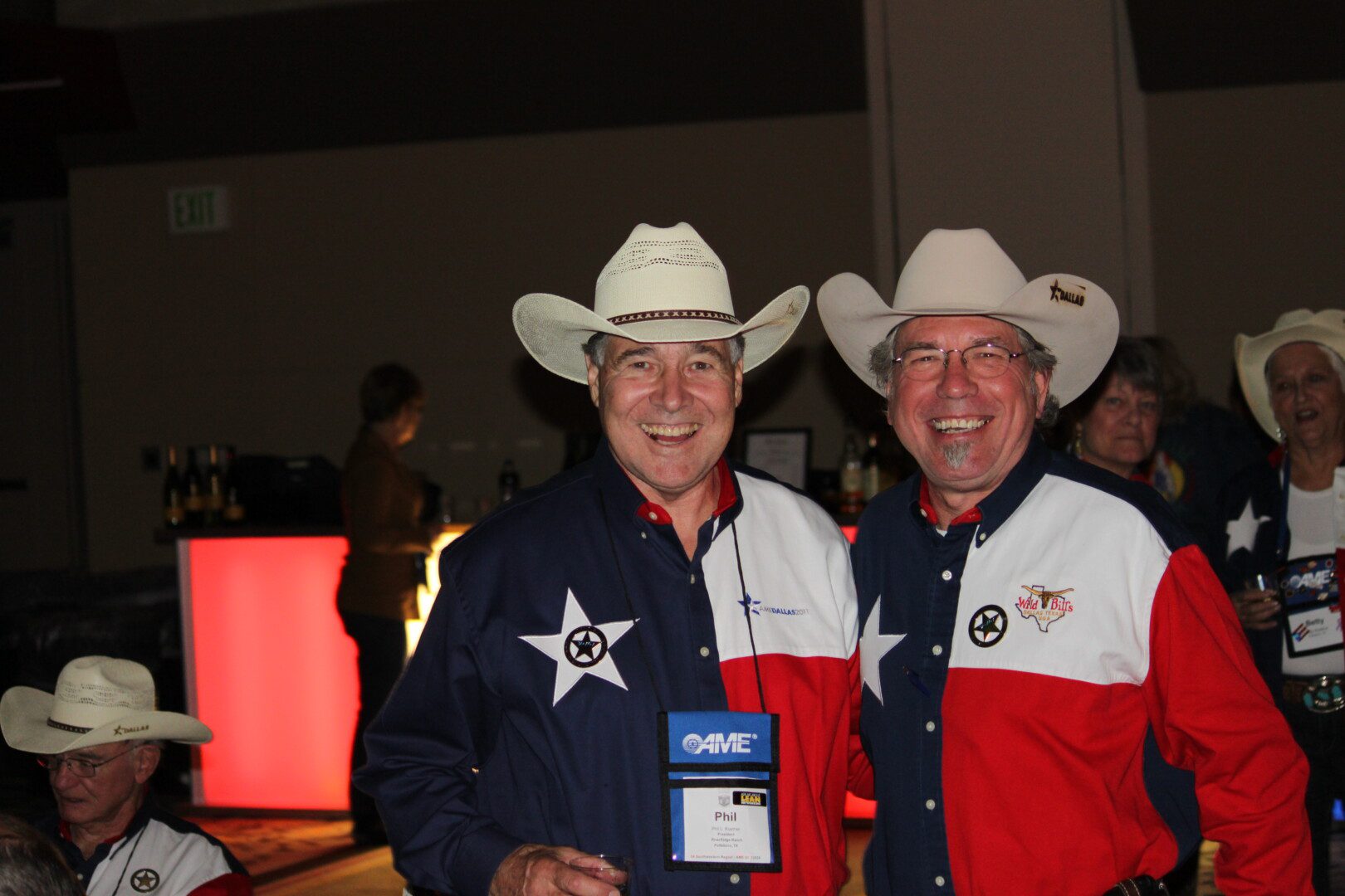 Two men in cowboy hats and jackets posing for a picture.