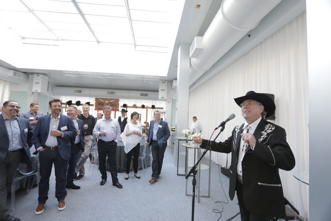 A man in cowboy hat speaking to people.