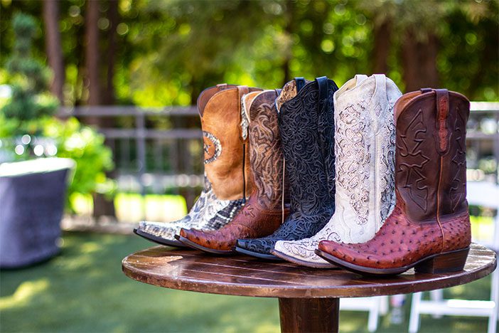 A bunch of cowboy boots sitting on top of a table.