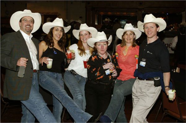 A group of people in cowboy hats posing for the camera.