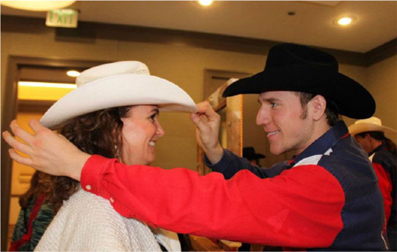 A man and woman wearing cowboy hats.