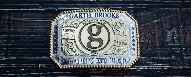 A belt buckle with the name of garth brooks on it.