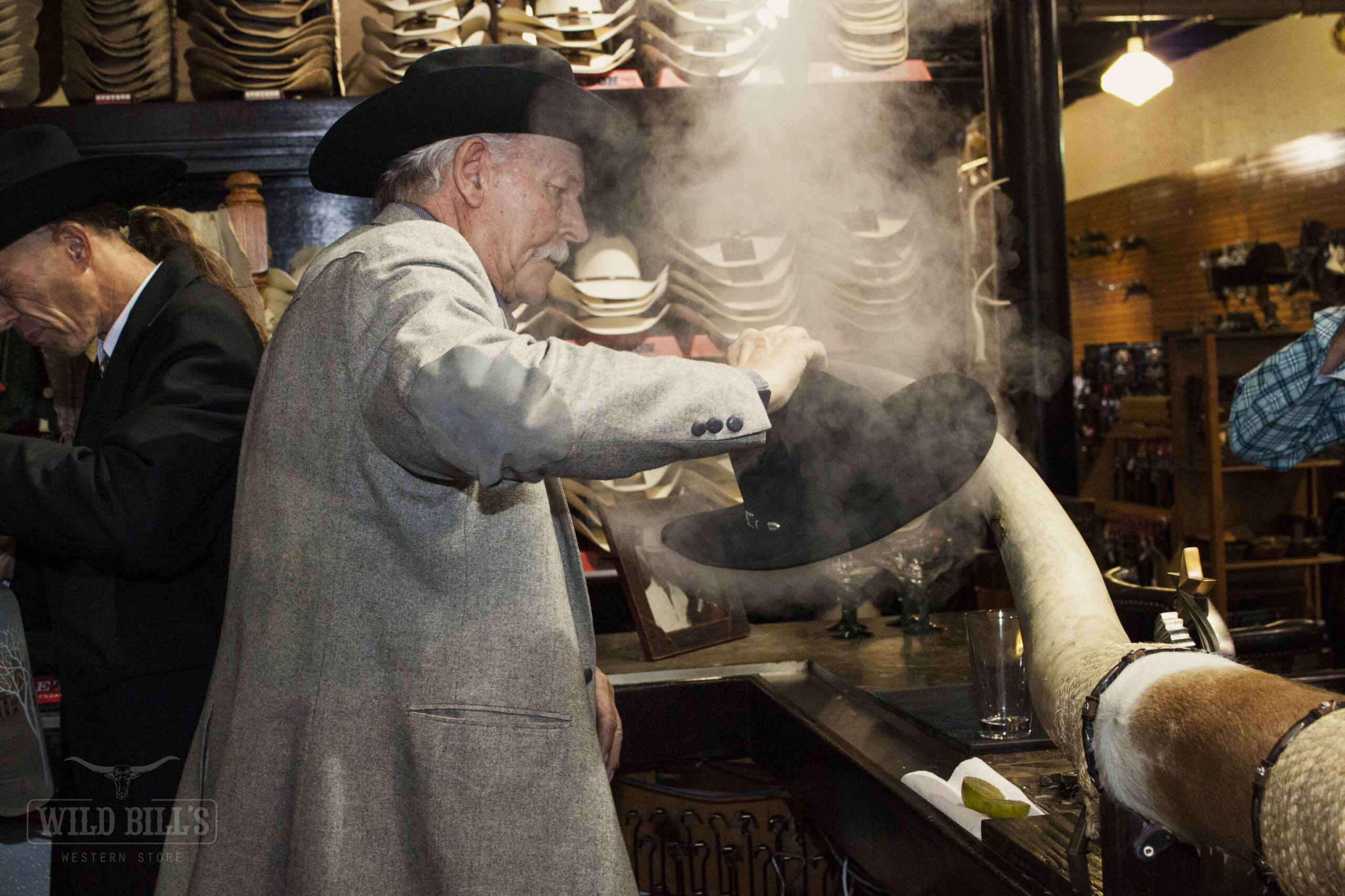A man in a hat and coat is cooking food.